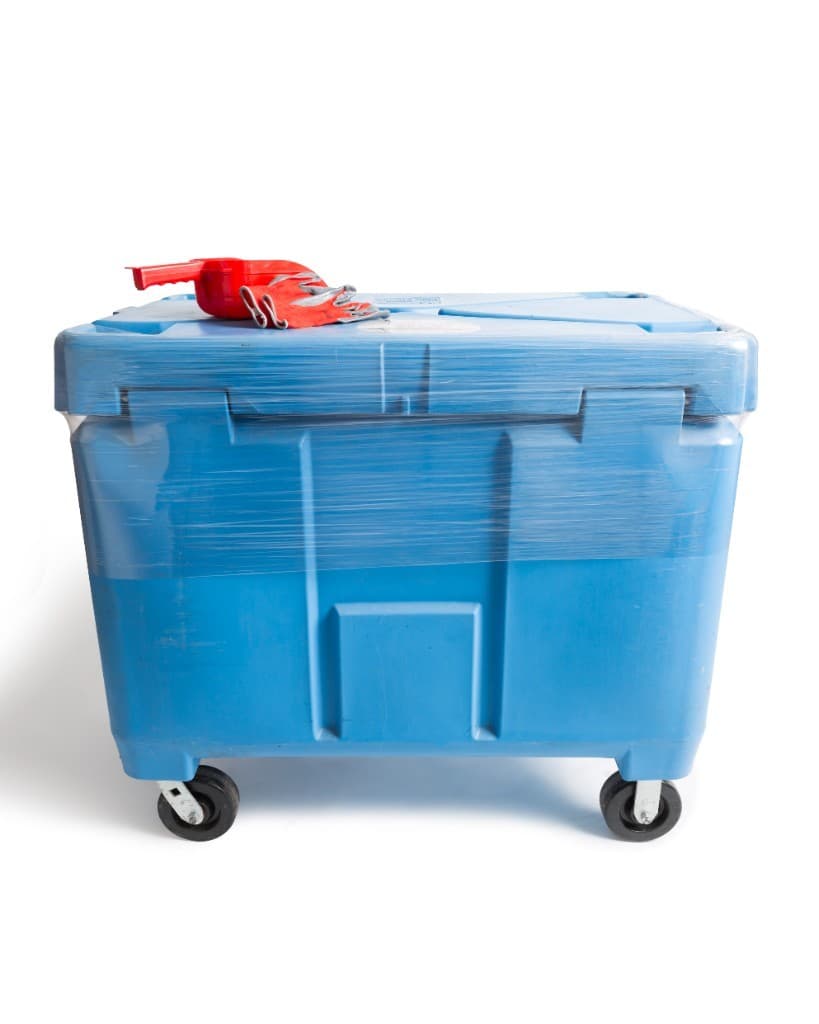 A blue 500 lb dry ice tote on wheels, with a red scoop and gloves on the lid.